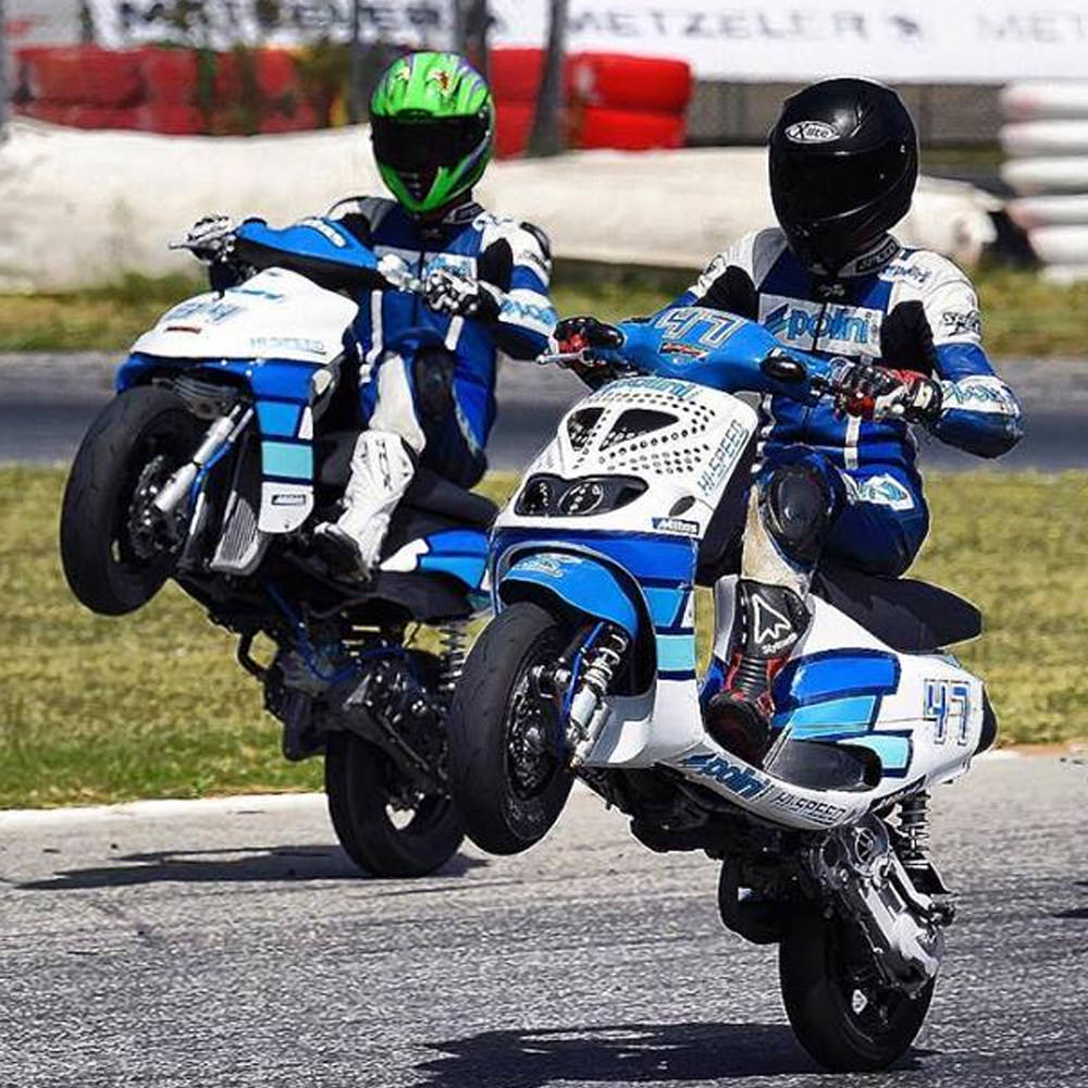 Dois pilotos conduzem scooters Polini em pista